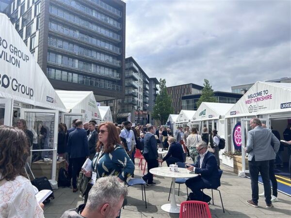 Groups of delegates visiting tented areas outside at UKReiif