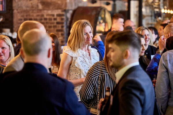 Woman in cream shirt in the centre of the image and two men in the foreground