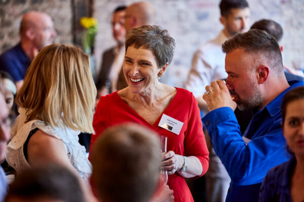 Woman in red dress laughing in a group of people