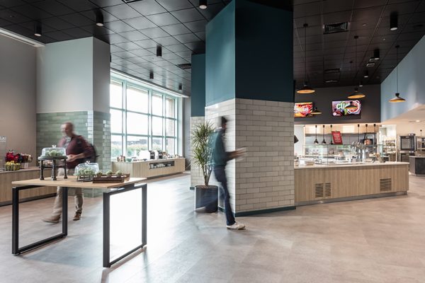 Canteen area with seperated spaces. Kitchen offering hot food, breakfast bar and table of healthy snack option.