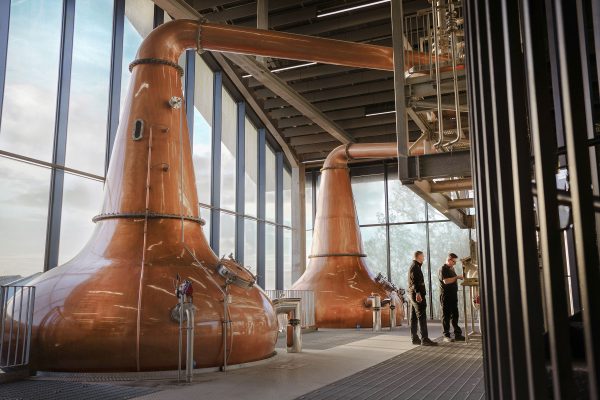 Inside a distillery, copper coloured machinery.