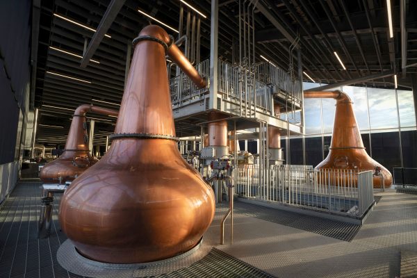 Inside a distillery, copper coloured machinery.