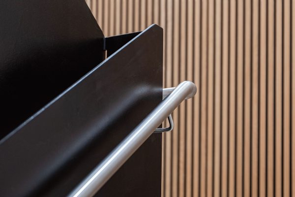 Steel railing for the stairs which reflects off of the black frame for the staircase.