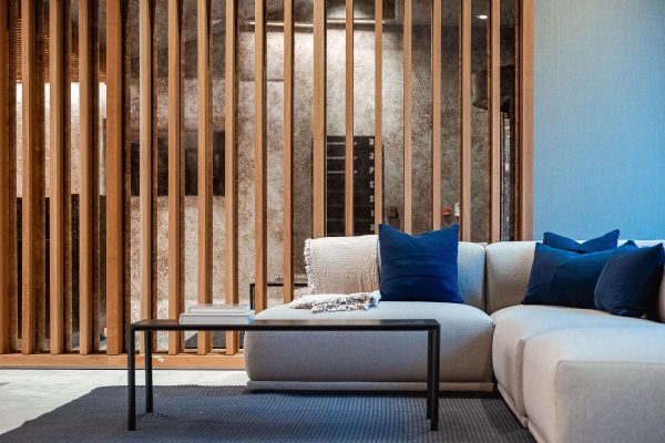 A couch and table which is surrounded by wooden pillars to separate the area.