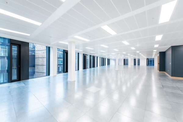 A large space with white and black walls and grey tile flooring.