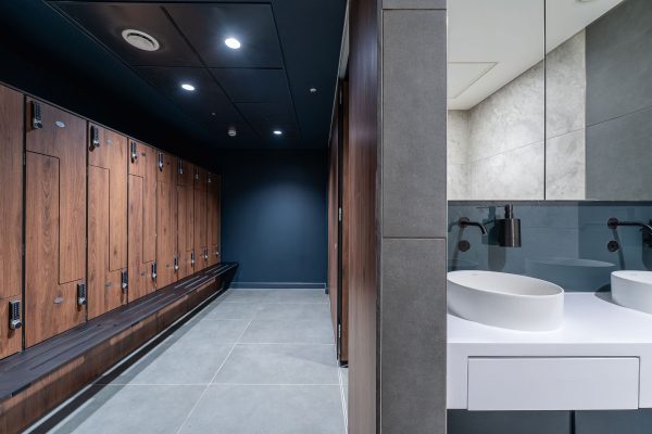 Changing rooms with dark walls and dark oak lockers which harmonize well together.